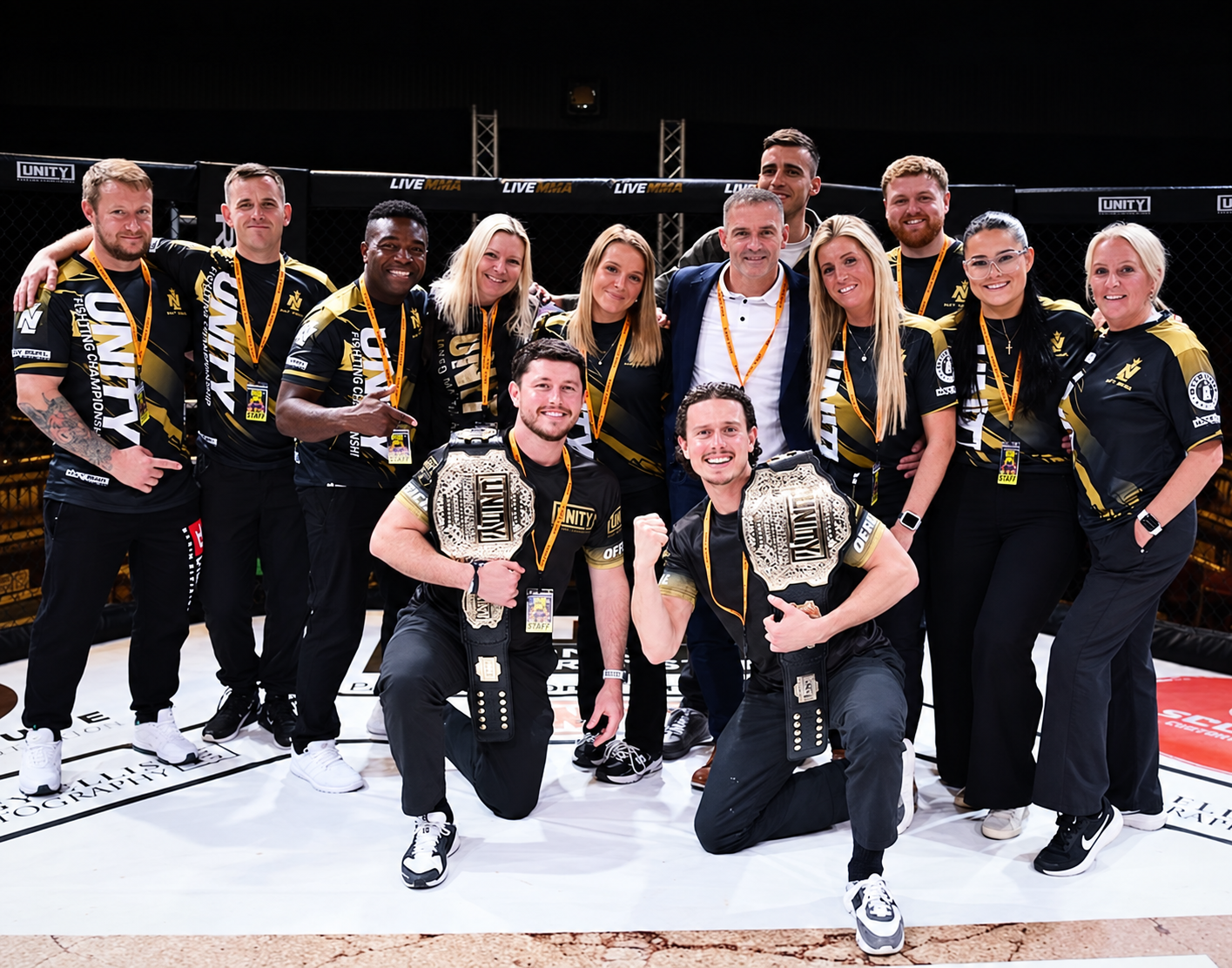 Unity team inside the MMA cage with championship belts